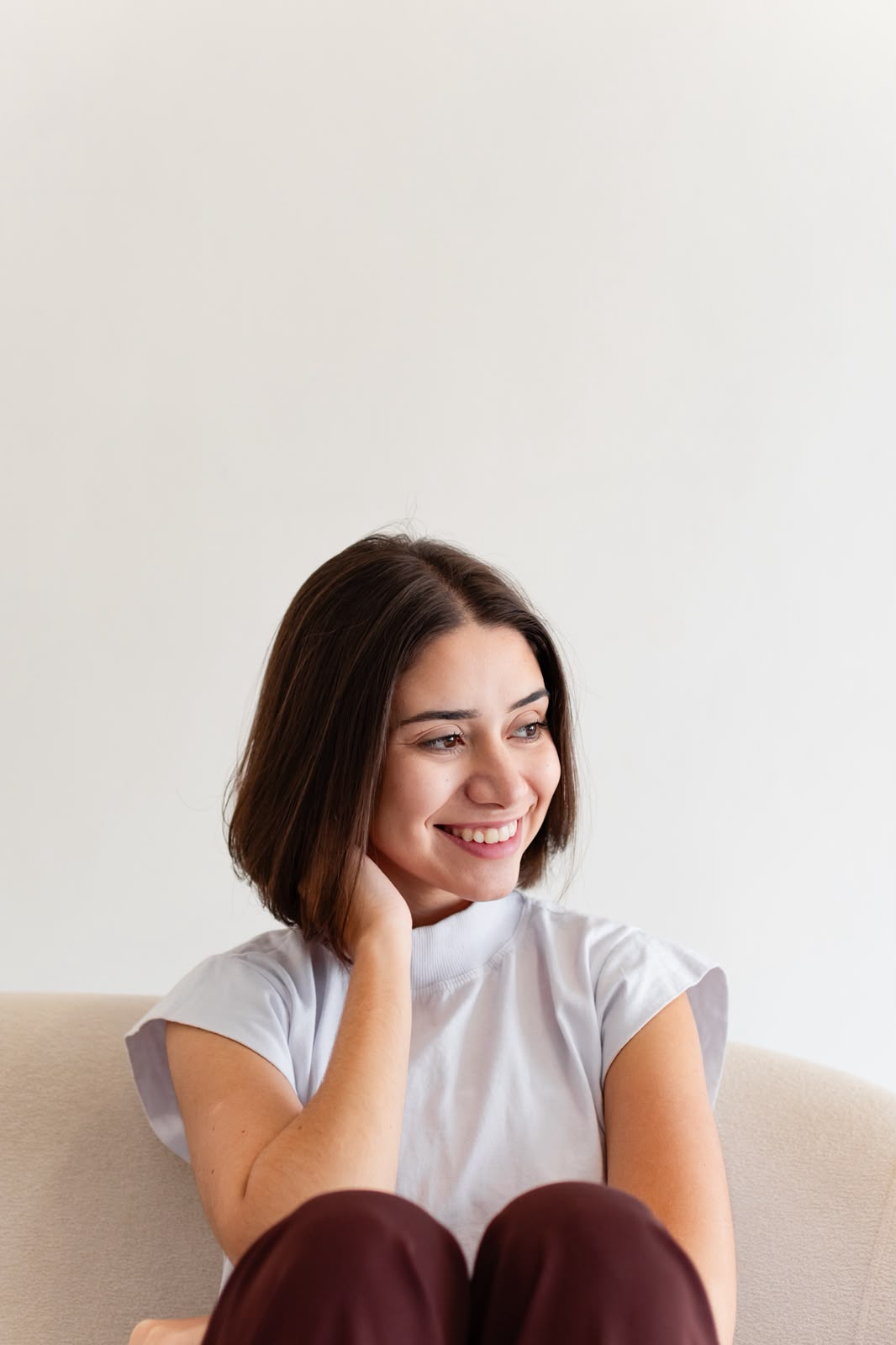 Ana Maria, psicóloga clínica, sentada e sorrindo